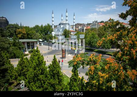 Ankara, Turquie - 13 juin 2022 : la grande mosquée blanche avec quatre minarets domine la ligne d'horizon, l'entrée voûtée et le toit en forme de dôme luisant à la lumière du soleil Banque D'Images