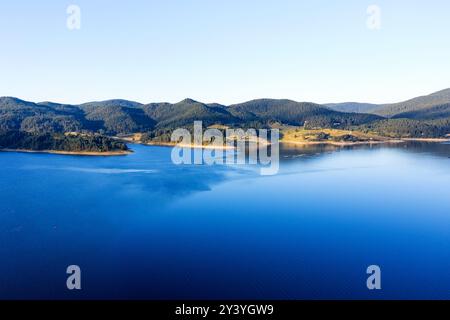 Lac et montagnes entourés de forêts en Bulgarie. Fermes piscicoles de truites et autres poissons sur le lac. Prise de vue aérienne avec un drone Banque D'Images