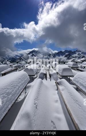 Oberstdorf, Allemagne. 15 septembre 2024. Bancs et tables recouverts de neige fraîche se dressent à la station intermédiaire de Fellhorn, haute de 1780 mètres, avec pour toile de fond les Alpes. Il a neigé une quantité inhabituellement importante pour la période de l'année dans les Alpes bavaroises. Crédit : Karl-Josef Hildenbrand/dpa/Alamy Live News Banque D'Images