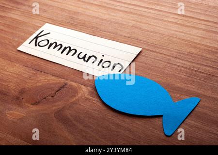 Communion. Mot allemand. Poisson bleu dans le coin. Pose sur bois. Espace libre pour le texte. Espace libre pour le texte. Banque D'Images