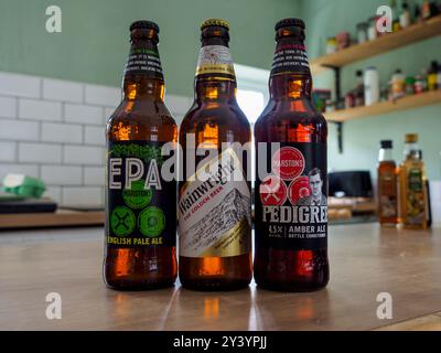 Manchester, Royaume-Uni, 9 septembre 2024 : trois bouteilles de bière assorties placées sur un comptoir de cuisine. Banque D'Images