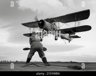 Un batteur signalant un Fairey Swordfish, un bombardier torpilleur et un grand biplan avec un cadre en métal recouvert de tissu, spécifiquement pour une utilisation de transporteur car il avait des ailes pliantes. Utilisé par la Fleet Air Arm de la Royal Navy pendant la seconde Guerre mondiale, il était effectivement connu sous le nom de « Stringbag » par ses équipages, mais il était déjà obsolète lorsque la guerre a commencé. Il a été exploité comme avion d'attaque principal jusqu'en 1942, date à laquelle il a été redéployé dans un rôle anti-sous-marin. Banque D'Images