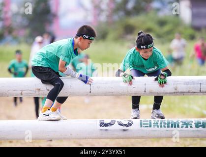 Pékin, province chinoise du Jiangsu. 15 septembre 2024. Les enfants participent à une compétition sportive amusante dans la zone pittoresque de l'île de Liandao à Lianyungang, dans la province du Jiangsu de l'est de la Chine, le 15 septembre 2024. Le festival de la mi-automne est l'une des fêtes traditionnelles les plus importantes de Chine. Ayant lieu annuellement le 15ème jour du huitième mois du calendrier lunaire chinois, il sera observé le 17 septembre de cette année. Crédit : Wang Jianmin/Xinhua/Alamy Live News Banque D'Images