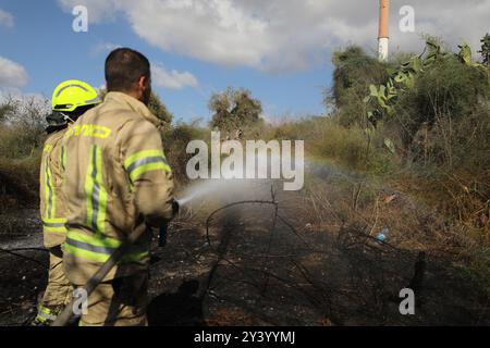 LOD, Lod dans le centre d'Israël. 15 septembre 2024. Les pompiers travaillent pour éteindre un incendie causé par un missile sol-sol, près de Lod dans le centre d’Israël, le 15 septembre 2024. Un missile sol-sol à longue portée tiré depuis le Yémen a frappé dimanche une zone inhabitée près de l'aéroport international d'Israël à l'extérieur de tel Aviv, selon des sources israéliennes. Crédit : Jamal Awad/Xinhua/Alamy Live News Banque D'Images