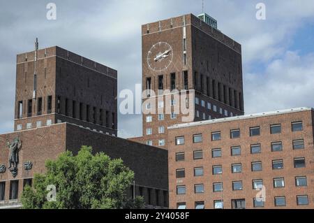 Bâtiment en brique avec tour de l'horloge de l'hôtel de ville sous un ciel nuageux, oslo, norvège Banque D'Images