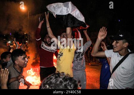 Gaza, Palestine. 24 avril 2021. Les Palestiniens brûlent des pneus et hissent le drapeau palestinien lors d'une manifestation à l'ouest de la ville de Gaza en soutien aux Palestiniens de Jérusalem-est. Depuis le début du Ramadan, le 13 avril, les tensions sont élevées à Jérusalem-est, dans un premier temps, à la suite de l'interdiction par les autorités israéliennes de se réunir autour de la porte de Damas, dans la vieille ville, où les Palestiniens ont tendance à se rassembler le soir pendant le Ramadan. Les tensions se sont encore aggravées jeudi soir lorsque des extrémistes juifs ont défilé près de la vieille ville de Jérusalem-est en scandant "mort aux Arabes" et en affrontant Banque D'Images