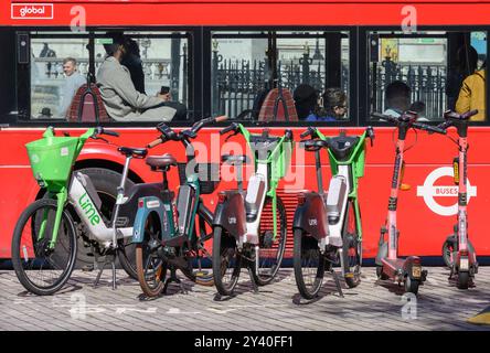 Londres, Royaume-Uni. Vélos de location de chaux garés comme un bus rouge londonien passe Banque D'Images