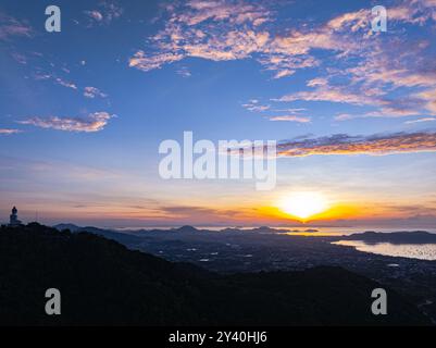 Vue aérienne Un paysage serein capturant les teintes douces de l'aube tandis que la brume s'installe sur des chaînes de montagnes lointaines sous un ciel aux couleurs pastel. Incroyable rose s Banque D'Images