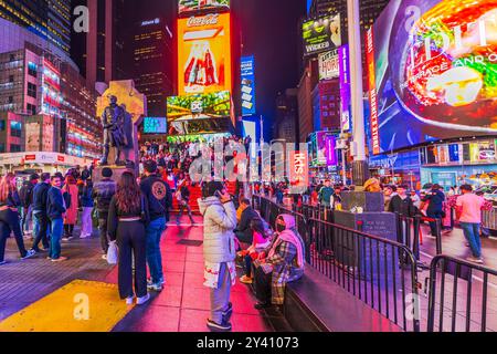 Vue nocturne de Times Square avec piétons, escalier rouge et gratte-ciel avec panneaux LED. New York. ÉTATS-UNIS. Banque D'Images