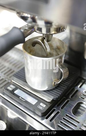 Infusion d'espresso dans une tasse en métal avec une machine espresso professionnelle. Banque D'Images