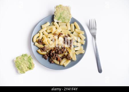 Pâtes marines avec bœuf haché et pain grillé à l'avocat sur une assiette grise, vue de dessus. Plats de viande halal Banque D'Images