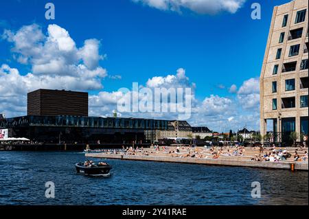 Les canaux de Copenhague vus de Christianshavn avec vue sur le Royal Danish Playhouse ( Skuespilhuset ) et les gens appréciant le soleil sur le front de mer Banque D'Images