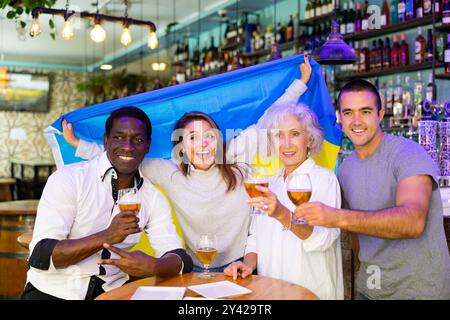 Heureux fans célébrant la victoire de l'équipe ukrainienne au bar Banque D'Images