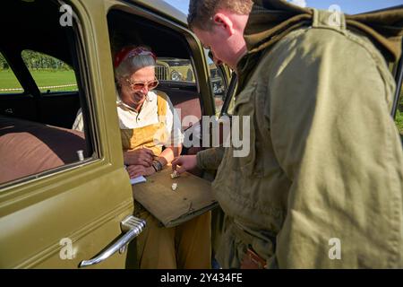 Pendant qu'ils attendent, les reconstituteurs jouent un jeu. Environ deux cents véhicules de l'armée de la seconde Guerre mondiale conduisaient en procession le long de la route originale (Hell's Highway) des Alliés. L'opération de libération Market Garden a commencé par des atterrissages aériens en septembre 1944. L'objectif était de capturer et de tenir une série de ponts stratégiques sur les rivières et les canaux. L'avance des troupes terrestres vers Eindhoven a eu lieu sur un front étroit, une route à deux voies qui courait vers le nord. Cela rend le 30e corps d'armée extrêmement vulnérable aux contre-attaques allemandes répétées et féroces. La route avancée était constamment u Banque D'Images