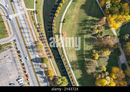 route asphaltée traversant une zone résidentielle près d'un canal d'eau. vue aérienne dans la journée ensoleillée d'automne. Banque D'Images