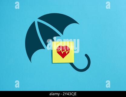 Concept d'assurance maladie. Symbole de coeur sur un papier de note collant avec icône de parapluie sur fond bleu. Banque D'Images