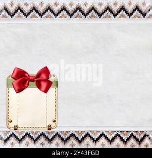 Fond horizontal de Noël avec texture de tissu tricoté et étiquette en cuir avec noeud. Texture de pull en laine de couleur marron et blanche avec orne géométrique Banque D'Images