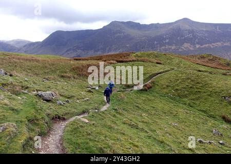 Deux hommes (randonneurs) escaladant le Wainwright 'Whiteless Pike' depuis 'Rannerdale Knotts' Buttermere, Lake District National Park, Cumbria, Angleterre, Royaume-Uni. Banque D'Images