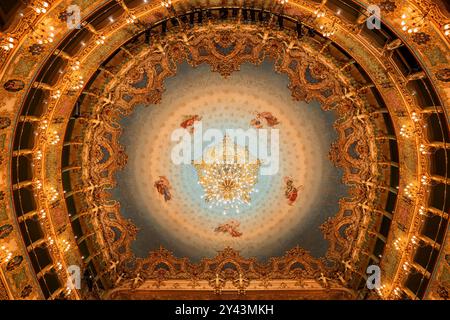 Venise, Italie - 24 mars 2024 - intérieur de l'opéra du Teatro la Fenice, intérieur orné de style rococo, vue sur le plafond avec peintures et chandelie Banque D'Images