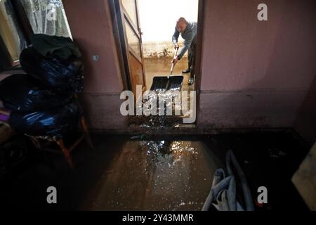 Galati, Roumanie. 15 septembre 2024. Un homme nettoie les eaux de crue à sa résidence dans le comté de Galati, Roumanie, le 15 septembre 2024. Le comté de Galati, en Roumanie, peine à se remettre des graves inondations provoquées samedi par le cyclone Boris, qui a coûté la vie à cinq personnes et déplacé plus de 250 résidents. Crédit : Cristian Cristel/Xinhua/Alamy Live News Banque D'Images