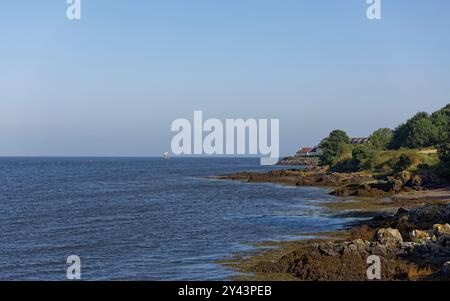 Regardant vers l'embouchure de l'estuaire de Tay avec des chalets de Tayport sur le rivage rocheux et la structure maritime en bois du Larrick dans le Banque D'Images