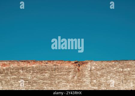 Vieux mur de briques en ruine sous le ciel bleu clair, foyer sélectif Banque D'Images