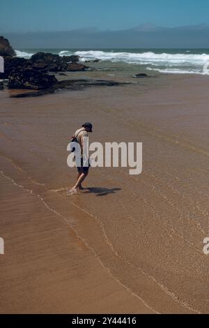 Homme regardant loin tout en se tenant sur l'océan à la plage. Banque D'Images