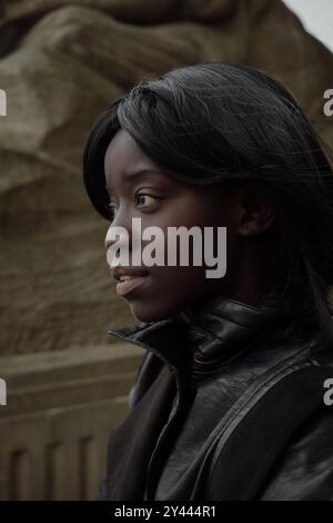 Jeune femme noire dehors. Elle porte une veste noire Banque D'Images