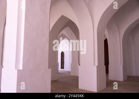 Un couloir long et étroit avec des arches blanches de chaque côté Banque D'Images