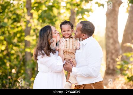 Parents serrés et souriants à leur jeune fils Banque D'Images