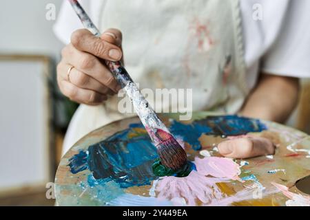 Une artiste passionnée mélange des couleurs vibrantes sur sa palette. Banque D'Images