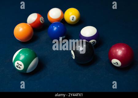 Boules de billard dans un ordre aléatoire. Gros plan d'une boule de billard de différentes couleurs. Jeu sportif de billard sur un tissu bleu. Ballons de snooker est prêt pour pla Banque D'Images