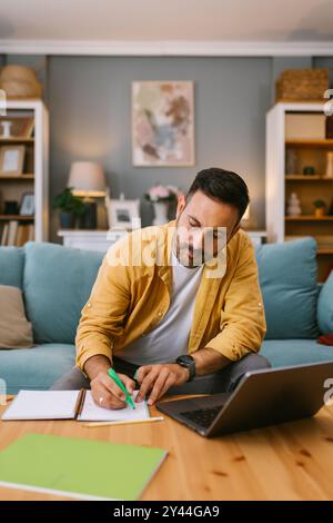 Nomade numérique travaillant à domicile avec un ordinateur portable et des notes Banque D'Images