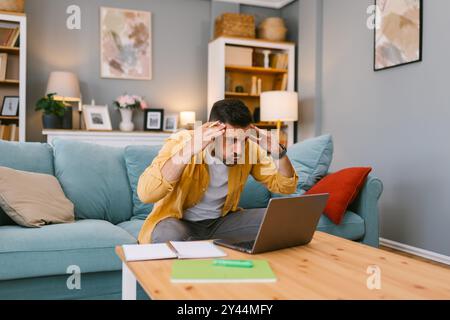 Homme stressé qui traite un problème sur son ordinateur portable Banque D'Images