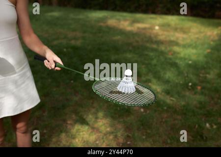 Gros plan raquette Badminton et navette à l'extérieur isolé sur fond d'herbe verte. Banque D'Images