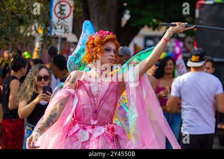 Goiania, Goias, Brésil – 08 septembre 2024 : une femme trans, toute habillée, vêtue de rose, dansant dans la rue pendant la parade de la fierté LGBT. Banque D'Images