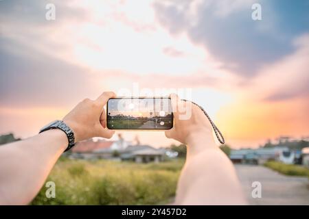 un homme qui prend des photos du paysage. il utilise un appareil photo de téléphone portable. situé dans une atmosphère naturelle lumineuse dans l'après-midi. Banque D'Images