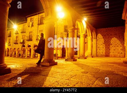 L'homme s'appuya contre une colonne à la recherche sur la place principale, vision de nuit. Sigüenza, province de Guadalajara, Castille La Manche, Espagne. Banque D'Images