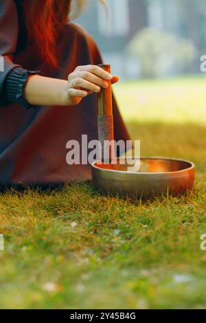 bol chantant joué par le thérapeute sur le vert en plein air Banque D'Images