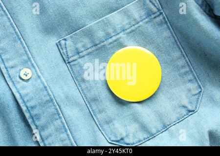 Badge bouton jaune épinglé sur la chemise en Jean, vue de dessus. Maquette pour le design Banque D'Images