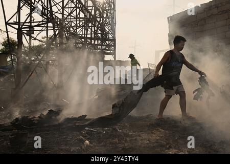 Suite à un incendie dans le Bacoor, Cavite, au sud de Manille les gens recherchent des matériaux recyclables parmi les débris de maisons brûlées causées par un incendie qui s'est produit la veille à Barangay Zapote, Bacoor, Cavite, le long du sud de Manille, Philippines, le 11 septembre 2024. Environ 1000 familles de colons informels vivant dans la zone côtière de Manille sont touchées par l'incendie, selon les responsables. Bacoor, Manille PHILIPPINES Copyright : xMatrixxImagesx/xNoelxCelisx Banque D'Images