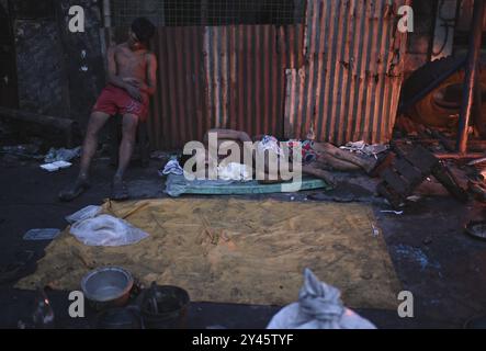 Suites d'un incendie dans le Bacoor, Cavite, au sud de Manille les hommes dorment le long d'une rue après qu'un incendie a brûlé leurs maisons causé par un incendie qui s'est produit la veille à Barangay Zapote, Bacoor, Cavite, au sud de Manille, Philippines, le 11 septembre 2024. Environ 1000 familles de colons informels vivant dans la zone côtière de Manille sont touchées par l'incendie, selon les responsables. Bacoor, Manille PHILIPPINES Copyright : xMatrixxImagesx/xNoelxCelisx Banque D'Images