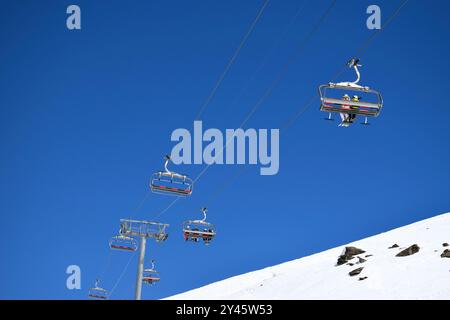 Télésièges pour skieurs et snowboarders par une journée claire et ensoleillée dans une station de ski française Banque D'Images