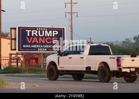 Pleasanton, États-Unis. 16 septembre 2024. Une camionnette blanche passe devant un panneau publicitaire de campagne Trump Vance le long de la Texas State Highway 97 dans le comté d'Atascosa, Texas, États-Unis, le 16 septembre 2024. Atascosa County est dans le sud du Texas, au sud de San Antonio. Les candidats républicains à la présidence ont remporté toutes les élections dans le comté d'Atascosa depuis l'an 2000. En 1996, le candidat démocrate à la présidentielle Bill Clinton l'a emporté sur le candidat républicain Bob Dole par une faible marge. (Photo de Carlos Kosienski/Sipa USA) crédit : Sipa USA/Alamy Live News Banque D'Images