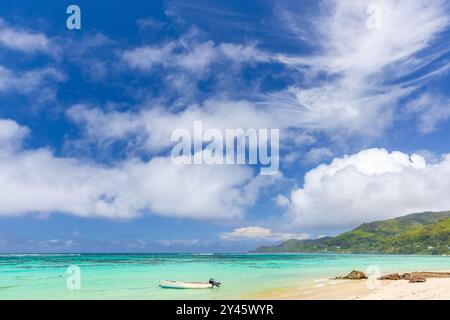 Plage d'Anse Royale, Seychelles. Vue côtière avec petit bateau à moteur sous ciel bleu par une journée ensoleillée Banque D'Images