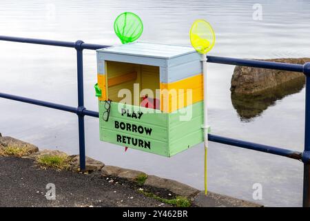 Coffre à jouets communautaire, attaché aux balustrades sur la promenade de Rothesay, île de Bute, Écosse, Royaume-Uni. Les jouets sont libres d'utiliser et de retourner une fois terminé. Banque D'Images