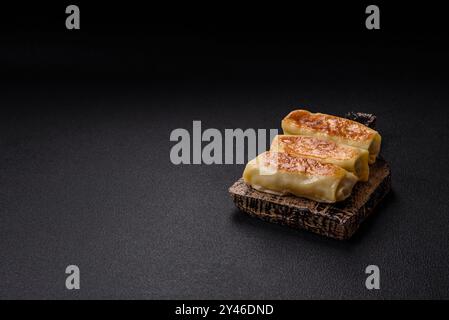 Crêpe sucrée ou salée avec différentes garnitures pour un petit déjeuner copieux sur un fond de béton foncé Banque D'Images