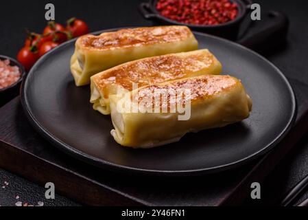 Crêpe sucrée ou salée avec différentes garnitures pour un petit déjeuner copieux sur un fond de béton foncé Banque D'Images