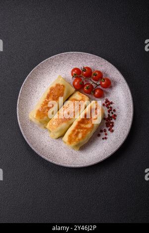 Crêpe sucrée ou salée avec différentes garnitures pour un petit déjeuner copieux sur un fond de béton foncé Banque D'Images