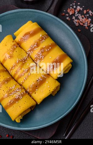 Crêpe sucrée ou salée avec différentes garnitures pour un petit déjeuner copieux sur un fond de béton foncé Banque D'Images